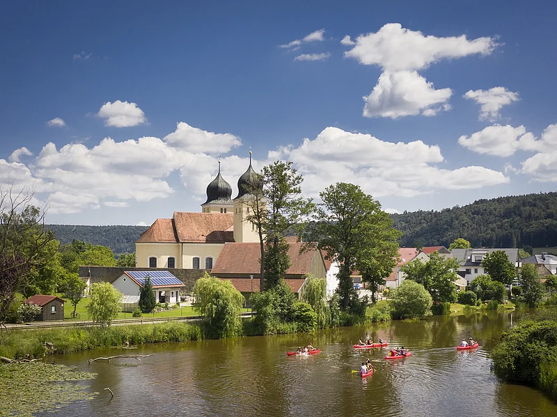 Bootwandern auf der Altmühl bei Kottingwörth Auf der Altmühl paddeln fünf rote Kanus an Kottingwörth mit ihrer Kirche und deren zwei Kirchtürmen vorbei.